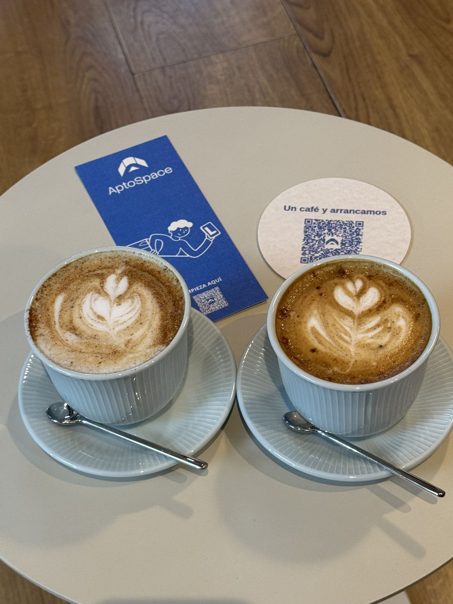 Dos cafés en AptoCafé junto al posavasos «Un café y arrancamos»